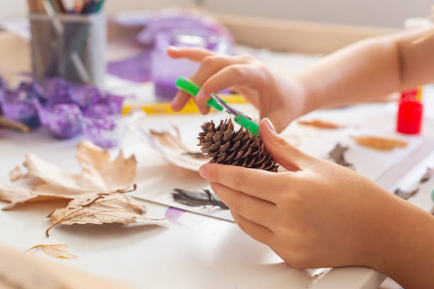 istock An unrecognizable child doing autumn handcrafts on a white wooden table. Various colored pencils in a metal pen holder visible in the background. 1427547397