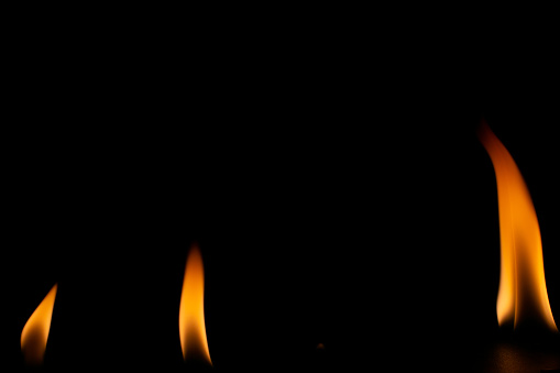 A hand lighting a candle with a matchstick
