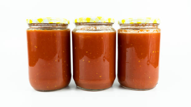 istock Tomato sauce in a jar. Homemade tomato sauce making process concept idea on white background. 1427551100