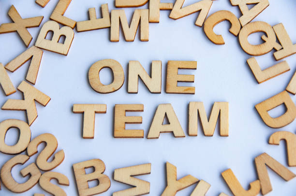 istock One team wooden text on while cover background. Teamwork concept 1427554966