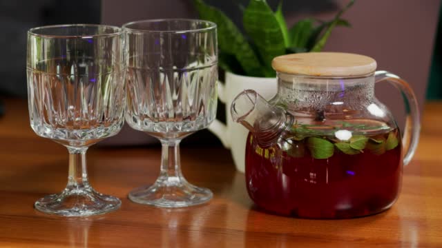 fruit vitamin tea in a transparent cup. Pour berry-fruit tea into a cup.