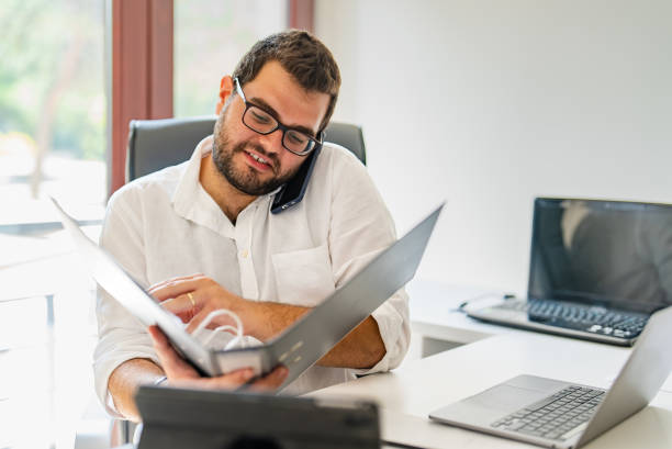 Young businessman examining document folder at his desk stock photo