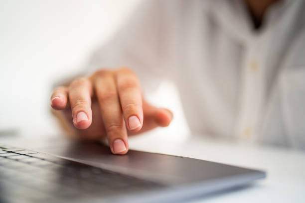 Man's finger touching laptop touchpad stock photo