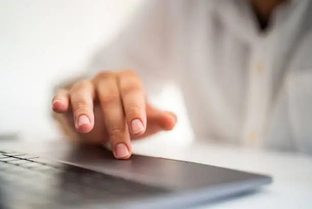 Photo of Man's finger touching laptop touchpad