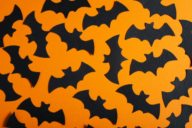 istock Orange background with black bats. Concept for Halloween 1427556956