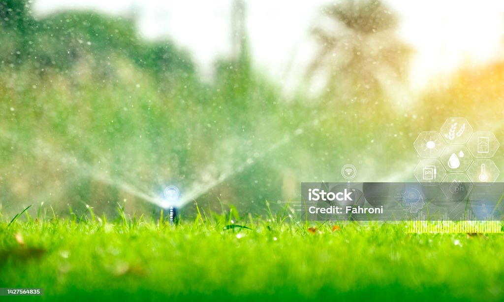 Automatic lawn sprinkler watering green grass and icon of smart farming concept. Smart agriculture with modern technology concept. Sustainable agriculture. Precision agriculture. Climate monitoring. Irrigation Equipment Stock Photo