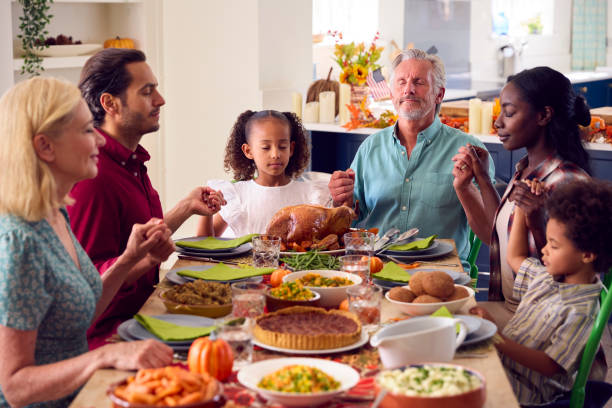 wielopokoleniowa rodzina świętująca święto dziękczynienia w domu odmawia modlitwę przed wspólnym posiłkiem - middle eastern ethnicity zdjęcia i obrazy z banku zdjęć