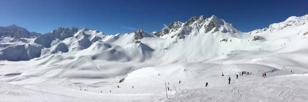 панорама снежных горных вершин и горнолыжных склонов в тине, горнолыжном курорте в альпах, франция - val disere стоковые фото и изображения