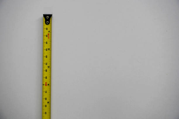 istock Construction bright yellow tape measure on a white wooden table. 1427567184