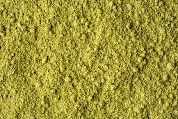 dry henna powder, lawsonia inermis, powdered leaves from henna tree or mignonette tree or egyptian privet, dye preparing herb full frame background