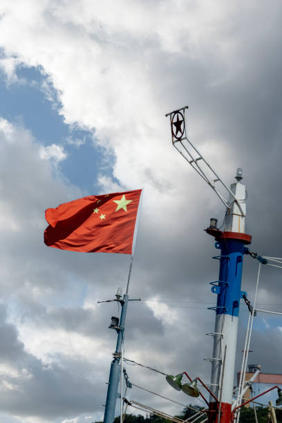 le drapeau chinois sur le navire de pêche océanique flotte haut sur le pont de la boussole - north sea audio photos et images de collection