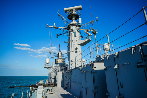 Image of  a military radar air surveillance on navy ship tower.
