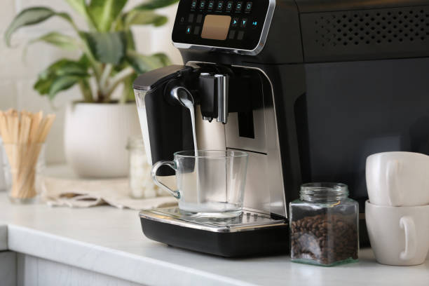 istock Modern coffee machine pouring milk into glass cup on white countertop in kitchen 1427569958