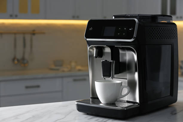 istock Modern electric coffee machine with cup on white countertop in kitchen 1427571204