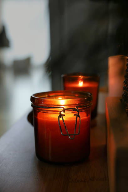 istock Lit candles on table in dark room. Space for text 1427571689