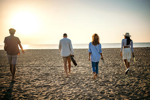 Happy attractive couple walking on beautiful sunny beach. Copy space