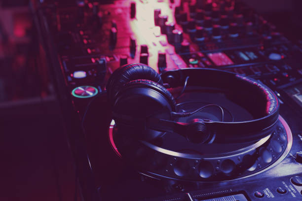 istock Closeup view of modern DJ controller with headphones on dark background 1427575236