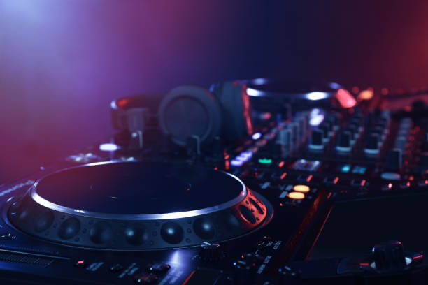 istock Closeup view of modern DJ controller with headphones on color background 1427575444