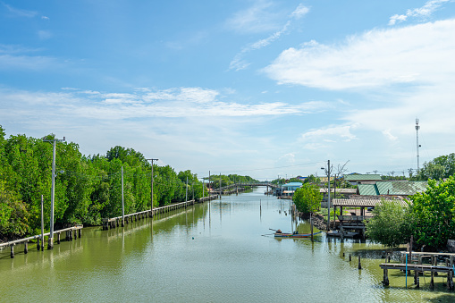 Beautiful scenic of the Khlong Sahakon from Bangkhunthian with the mangroove forest and the seaside village along the river in Bangkok, Thailand.