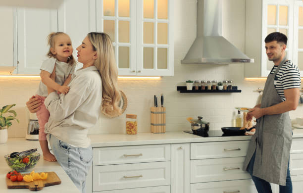 happy family spending time together while cooking in kitchen - two parent family indoors home interior domestic kitchen imagens e fotografias de stock