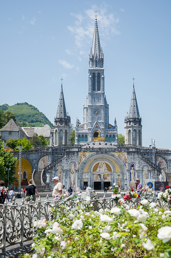 Editorial. July, 2022. Lourdes, France. Basilica of the Holy Rosary in Lourdes, France. Main facade of the Sanctuary at Lourdes. A gilded cross crowns the dome of the Basilica of the Holy Rosary.