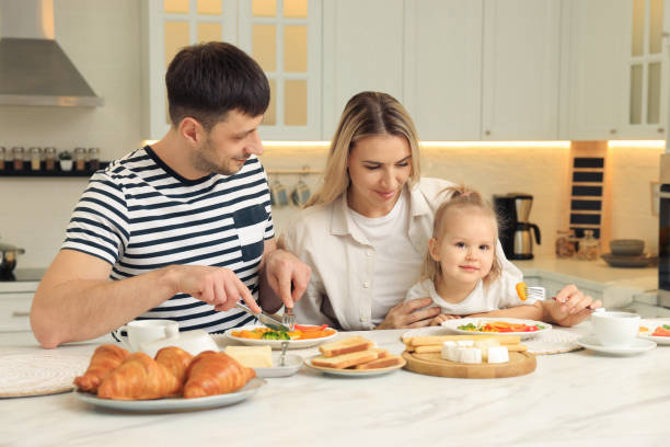 istock Happy family having breakfast together at table in kitchen 1427576663