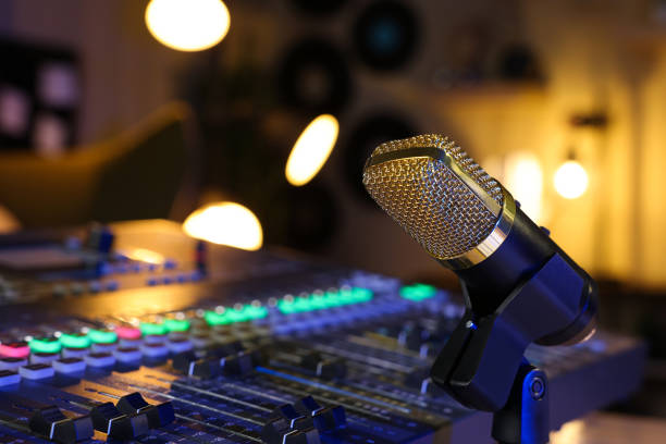 istock Microphone near professional mixing console in radio studio, closeup. Space for text 1427577774