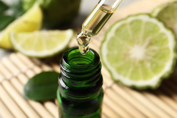 istock Dripping bergamot essential oil into glass bottle on table, closeup 1427578568