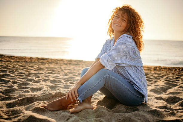 istock Young woman sitting on the beach 1427580516