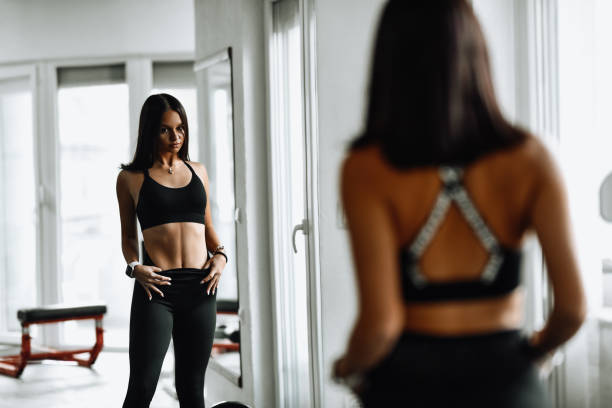 istock Beautiful Female Athlete Examining Workout Progress In Gym Mirror 1427581344