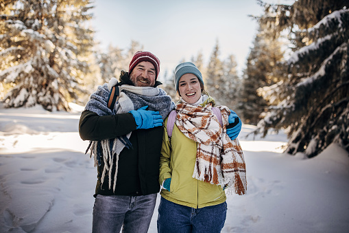 Man and woman, father and his adult daughter exploring nature together during winter days.