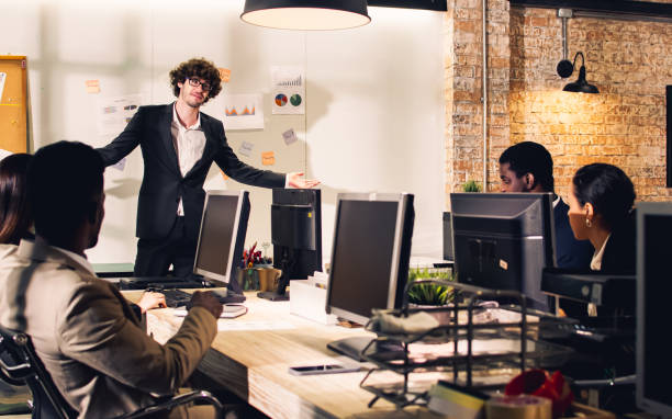 istock Selective focus young handsome smart Caucasian Businessman or boss wearing suit, smiling with happiness, confidence, presenting marketing plan or creative idea in meeting room at indoor modern office. 1427582925