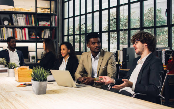istock Diverse and multiracial smart businesspeople wearing formal suits, using computer, working, meeting, brainstorming together about company marketing plan or creative idea in indoor modern office. 1427583513