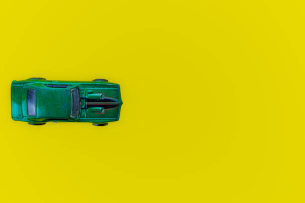 istock green toy car isolated on yellow background. top view 1427583694