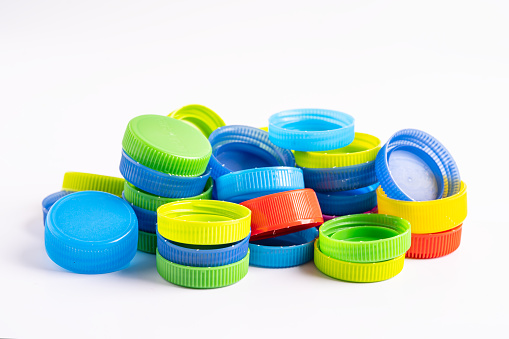 Plastic bottle colored screw caps for recycle waste on white background, container water lid.