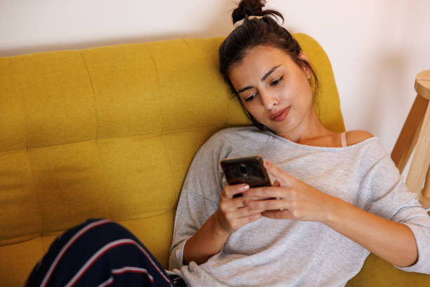istock Beautiful woman using phone at home 1427590122