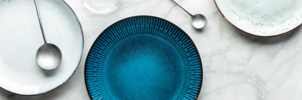 istock Modern tableware panorama with a vibrant blue plate and cutlery, overhead shot 1427594455