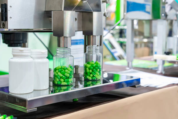 istock close up white with clear plastic bottle under nozzle dispenser component of automatic medicine capsule bottle filling and counting machine during manufacturing process 1427595795