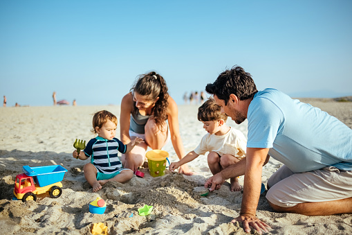 Shot of a young family spending quality time at the beach