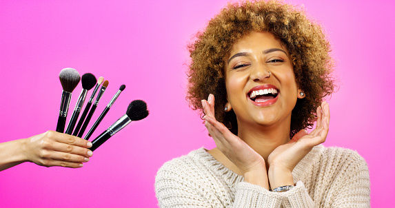 Makeup brushes, beauty and cosmetics black woman on in studio, retro pink background and mockup or copy space. Smile portrait of model with foundation, skincare and luxury facial product with mock up
