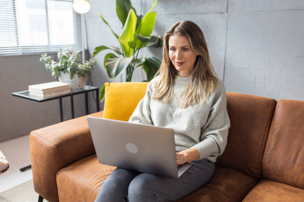 istock Mature woman using laptop on sofa 1427597072