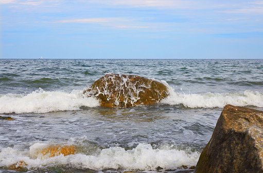 Waves on the Baltic Sea beach under blue sky