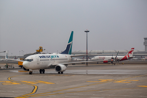 WestJet Boeing 737-7CT aircraft with registration C-GWSO being de-iced at Toronto Pearson International Airport in April 2022.