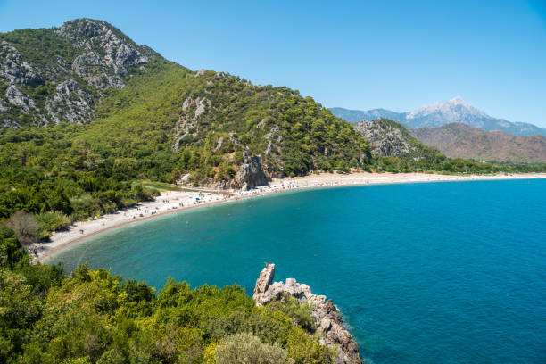 Landscape in Olympos holiday hamlet in Antalya province of Turkey. Landscape in Olympos holiday hamlet in Antalya province of Turkey. View of the beach with people and mountains in the background. cirali stock pictures, royalty-free photos & images