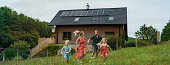 istock Happy family running near their house with solar panels. Alternative energy, saving resources and sustainable lifestyle concept. 1427608620