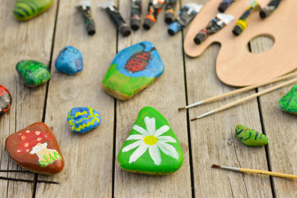 istock Flat stones painted with acrylic paints. Do it yourself. Souvenirs that children can make. 1427609698