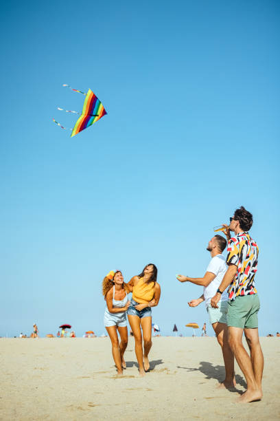 istock Young people flying kite on beach 1427609999