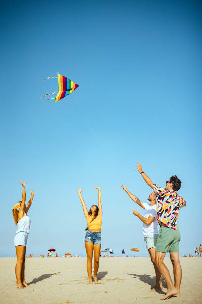 istock Young people flying kite on beach 1427610059