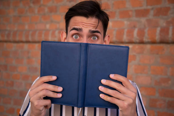 istock Young attractive student with a book. Happy man. 1427612008