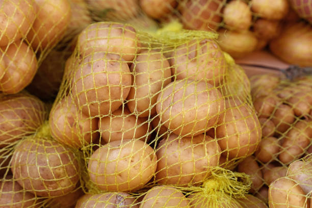 chiudi un mucchio di patate nuove all'esposizione al dettaglio - raw potato farmers market market stall vegetable foto e immagini stock